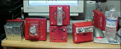 My fire alarm collection is readied for taking home, with back-boxes on some of the signals with more-delicate backs in order to protect them during transport.  Also, if you look at the full-size image, you can see a Web Cam image on the computer screen of me taking this picture.