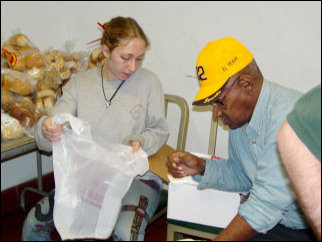Mary helps double up the bags for the food pantry. Mary helps double up the bags for the food pantry.
