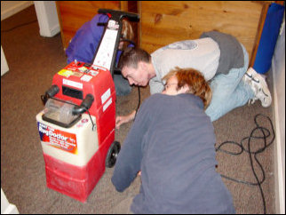 One of the Rug Doctor machines broke down on us! Here, Nicole, Mark, and Spencer take a look at it to try and figure out what was wrong with it. Turned out that it was nothing we could fix on the spot, but thankfully we had a backup, as Kathleen had her own Bissell steam cleaner. We used that. One of the Rug Doctor machines broke down on us! Here, Nicole, Mark, and Spencer take a look at it to try and figure out what was wrong with it. Turned out that it was nothing we could fix on the spot, but thankfully we had a backup, as Kathleen had her own Bissell steam cleaner. We used that.