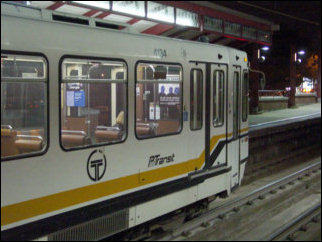 The T uses articulated light rail vehicles. Each light rail vehicle is two "cars", connected by a hinge in the middle (I'm oversimplifying, but you get the idea). Additionally, the lights go out for a few seconds inside the cars when the trains change wires. Only the blue lights stay on during these changeovers.
